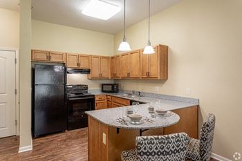 Fitted Kitchen With Island Dining at The Gardens at Jackson Creek, Independence, MO
